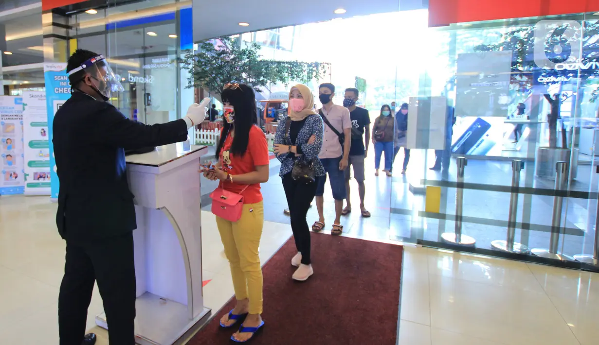 Petugas memeriksa suhu tubuh pengunjung di Mal Tangerang City, Banten, Selasa (23/6/2020). Sejumlah mal di Tangerang telah dibuka kembali dengan menerapkan protokol kesehatan dalam melayani masyarakat selama status Pembatasan Sosial Berskala Besar (PSBB). (Liputan6.com/Angga Yuniar)