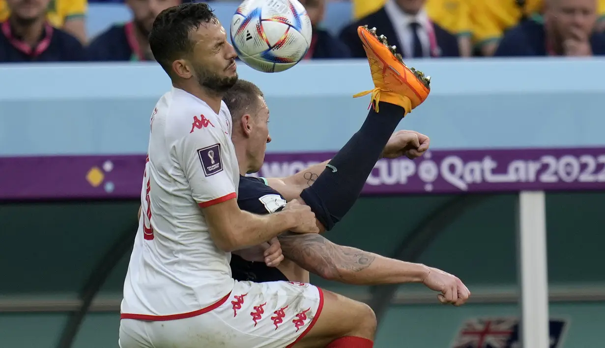 <p>Bek Tunisia, Montassar Talbi berebut bola dengan penyerang Australia, Mitchell Duke selama pertandingan grup D Piala Dunia 2022 di Stadion Al Janoub di Al Wakrah, Qatar, Sabtu, 26 November 2022. Australia menang tipis atas Tunisia dengan skor 1-0. (AP Photo/Ricardo Mazalan)</p>