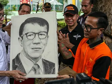 Menkumham Yasonna Laoly membeli sebuah lukisan karya seni seorang penghuni Lapas Salemba, Rabu (9/3/2016). Yasonna kunjungi lapas Salemba untuk mengecek dan mengontrol peredaran narkotika dalam lapas. (Liputan6.com/Yoppy Renato)