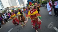 Aksi menari Mahasiswa Universitas Paramadina saat car free day di Bundara HI, Jakarta, Minggu (26/4/2015). Mereka meminta sumbangan kepada warga untuk mengikuti Interntional Folklore Festival di Spanyol. (Liputan6.com/Faizal Fanani)