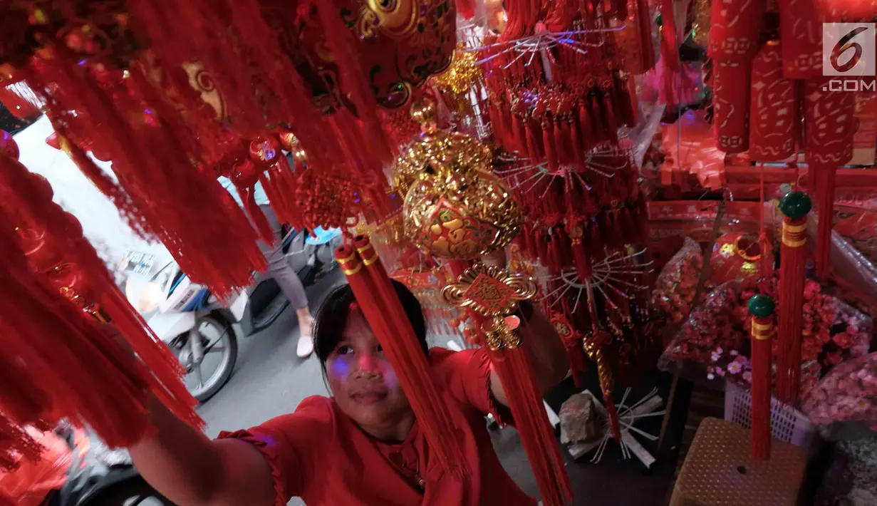 Pengunjung tengah memilih pernak-pernik Imlek di Glodok, Jakarta, Senin (22/1). Jelang perayan imlek sejumlah pedagang mulai menyajikan hiasan untuk merayakan Imlek 2018. (Liputan6.com/Angga Yuniar)