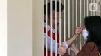 Terdakwa kasus pelanggaran UU ITE Adam Deni (kiri) berada dalam ruang tahanan Pengadilan Negeri Jakarta Utara, Selasa (7/6/2022). Adam Deni menjalani sidang lanjutan atas dugaan pelanggaran UU ITE yang beragendakan pembacaan nota pembelaan atau pledoi atas tuntutan 8 tahun penjara dari Jaksa Penuntut Umum (JPU). (Liputan6.com/Herman Zakharia)