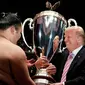 Presiden AS Donald Trump (kanan) memberikan trofi President's Cup kepada pemenang Tokyo Grand Sumo Tournament di Stadion Ryogoku Kokugikan, Tokyo, Jepang, Minggu (26/5/2019). Nonton bareng ini dilakukan di sela-sela kunjungan kenegaraan Trump ke Jepang. (AP Photo/Evan Vucci)