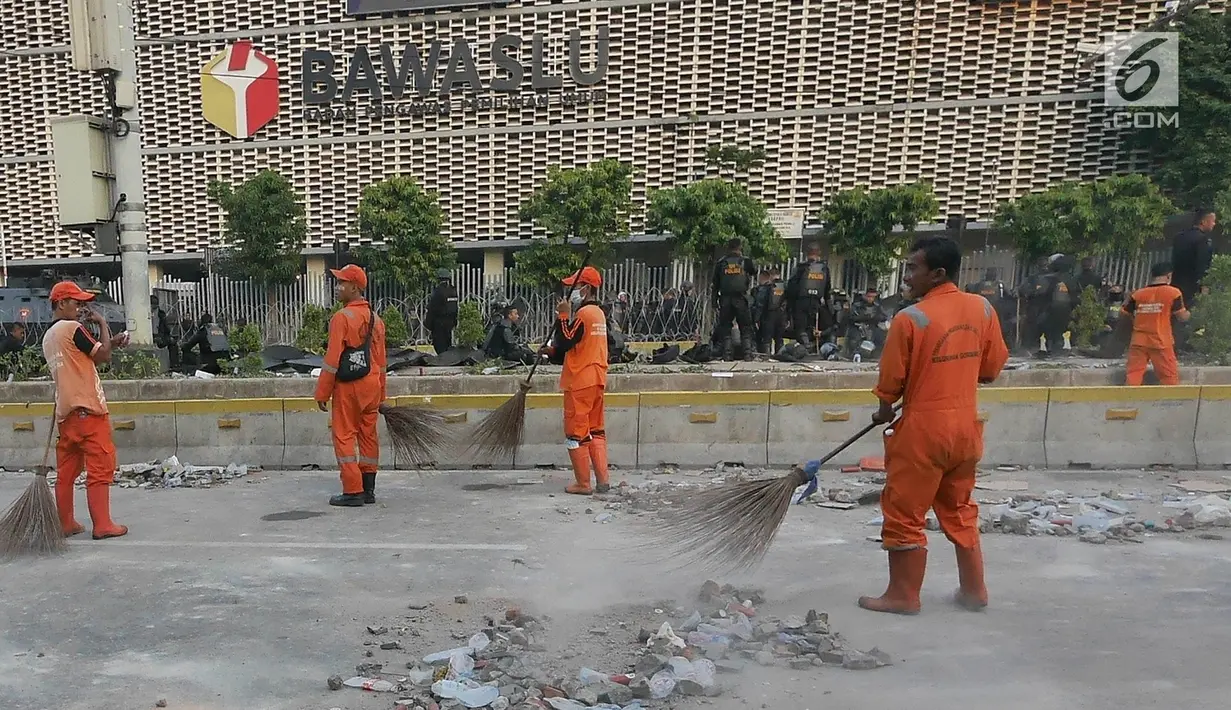 Petugas Penanganan Prasarana dan Sarana Umum (PPSU) atau Pasukan Oranye membersihkan sisa puing-puing pasca kerusuhan di MH. Thamrin, Kamis (23/5/2019). Bentrokan terjadi setelah pihak kepolisian berupaya membubarkan massa aksi yang masih bertahan di depan Bawaslu. (Liputan6.com/Herman Zakharia)