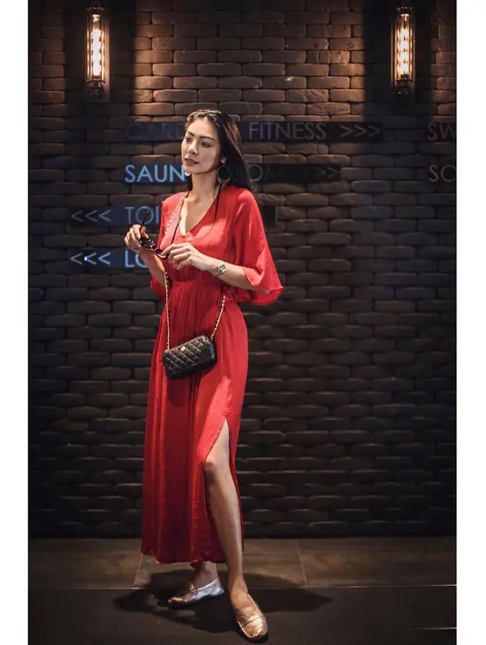Untuk yang satu ini misalnya, Faye mengenakan long dress merah yang belahannya sampai ke bagian paha. Tampak simple, ia memakai sneaker dan sling bag hitam kecilnya. (Instagram/faye_malisorn)