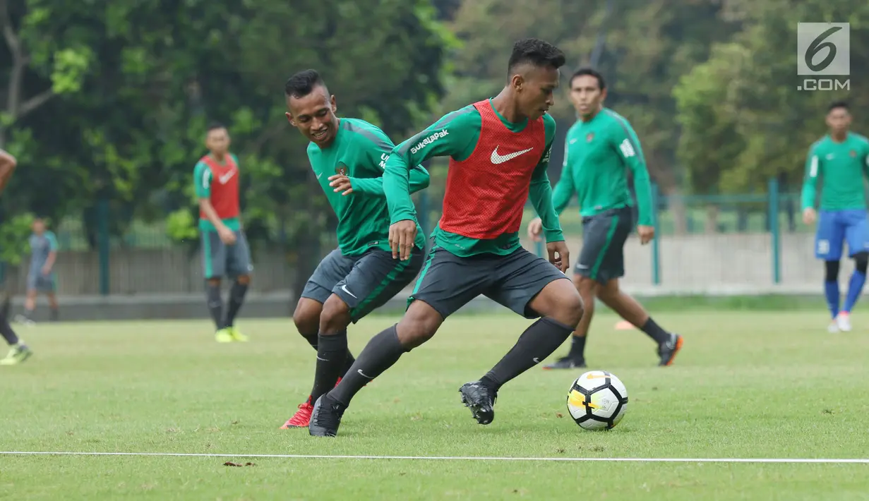 Pemain Timnas Indonesia U-23, Irfan Jaya (kiri) berebut bola dengan Osvaldo Haay saat latihan di Lapangan A Senayan, Jakarta, Sabtu (17/3). Latihan ini persiapan uji tanding melawan Singapura pada 21 Maret mendatang. (Liputan6.com/Helmi Fithriansyah)