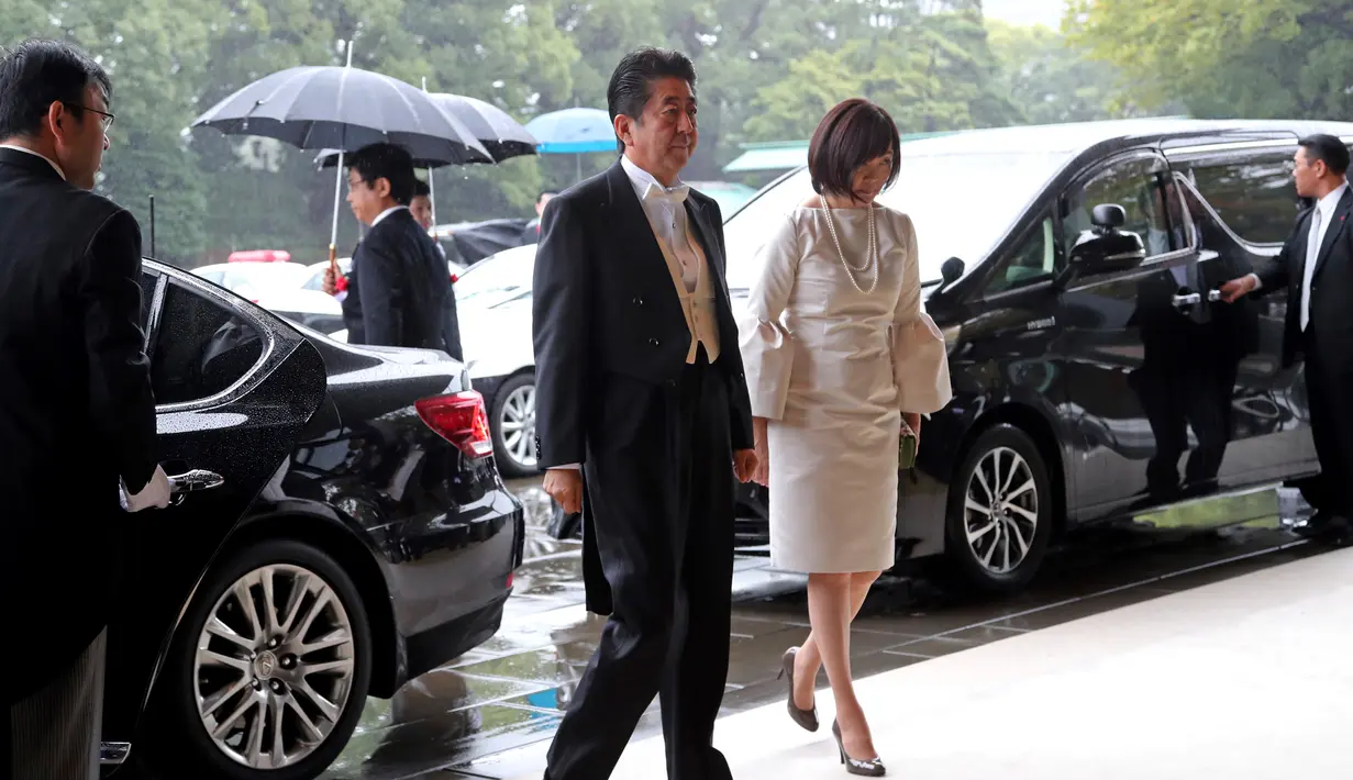 Perdana Menteri Jepang Shinzo Abe (kiri) dan istrinya Akie tiba untuk menghadiri upacara penobatan Kaisar Naruhito di Istana Kekaisaran, Tokyo, Jepang, Selasa (22/10/2019). Kaisar Jepang Naruhito akan menjalani rangkaian ritual penobatan resmi kekaisaran hari ini. (AP Photo/Koji Sasahara, Pool)