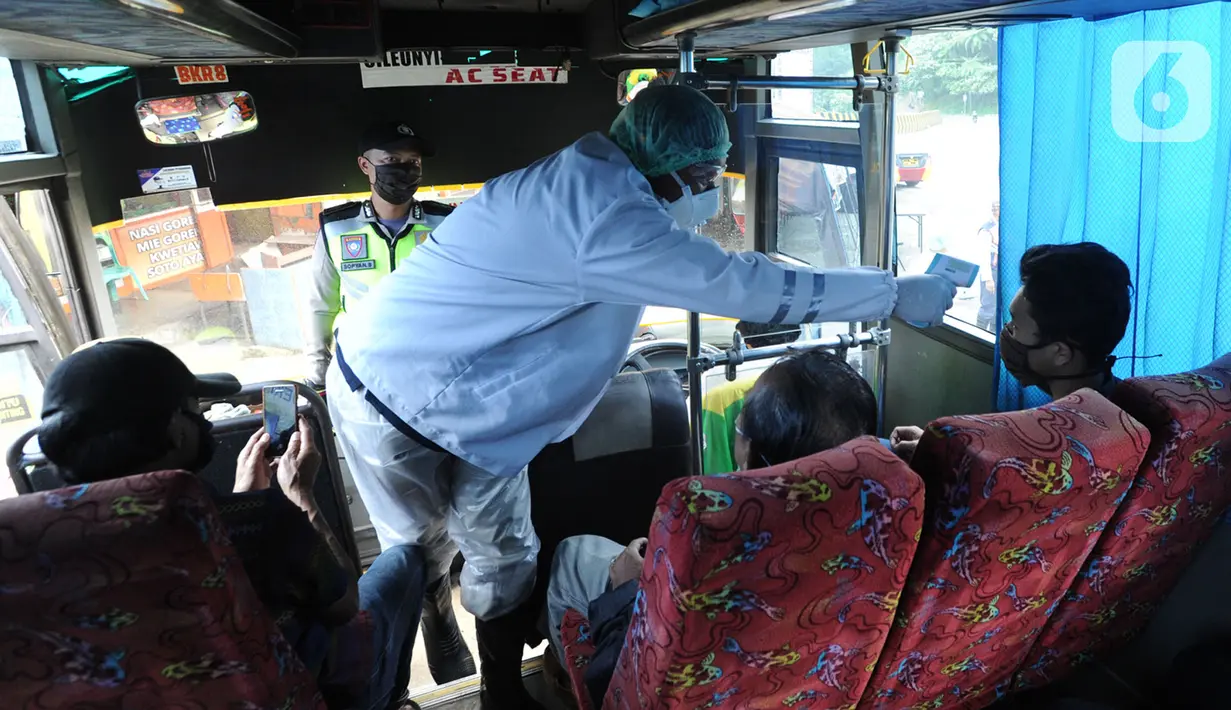 Petugas mengecek suhu tubuh penumpang bus saat penyekatan arus lalu lintas di Ciloto, Cianjur, Jawa Barat, Jumat (17/4/2020). Pemkab Cianjur melakukan pengecekan suhu tubuh dan penyemprotan disinfektan sejumlah titik keluar-masuk Cianjur untuk mencegah penyebaran COVID-19. (merdeka.com/Arie Basuki)