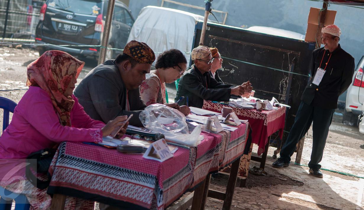 Petugas KPPS mengenakan pakaian adat dan belangkon saat bertugas di TPS 14 Cipinang Besar Selatan, Jakarta, Rabu (19/4). Petugas KPPS menggunakan pakaian adat agar warga tertarik untuk mencoblos di Pilkada DKI putara kedua. (Liputan6.com/Gempur M. Surya)