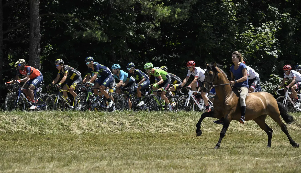 Seorang pengendara kuda mengiringi pebalap Tour de France pada etape ke-16 dengan jarak 165 km dari Le Puy-en-Velay dan Romans-sur-Isere, (18/7/2017).  (AFP/Lionel Bonaventure)