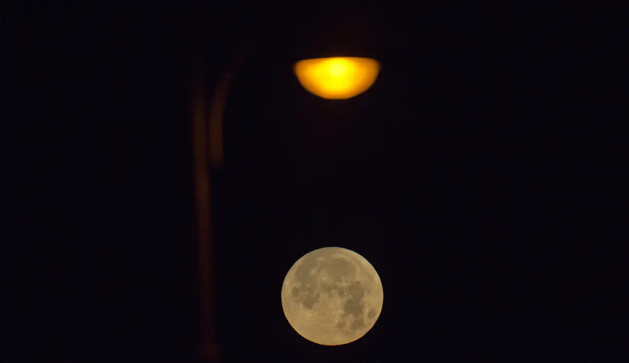 Pemadangan saat bulan terbenam di balik awan di laut Mediterania di lepas pantai Hadera, Israel, Rabu (31/1). (AP Photo / Ariel Schalit)