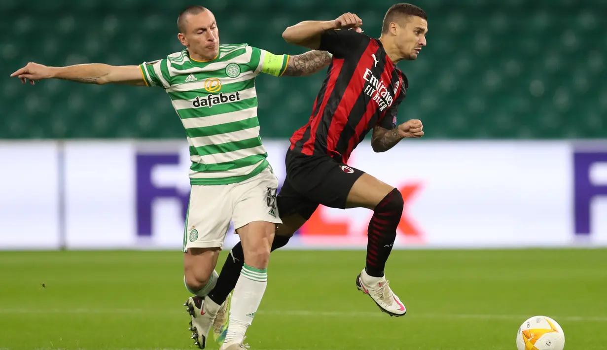 Gelandang AC Milan, Rade Krunic, Berebut bola dengan gelandang Celtic, Scott Brown, pada laga Grup H Liga Europa 2020/2021 di Celtic Park Stadion, Jumat (23/10/2020). AC Milan menang 3-1 atas Celtic. (AFP/Russell Cheyne/pool)
