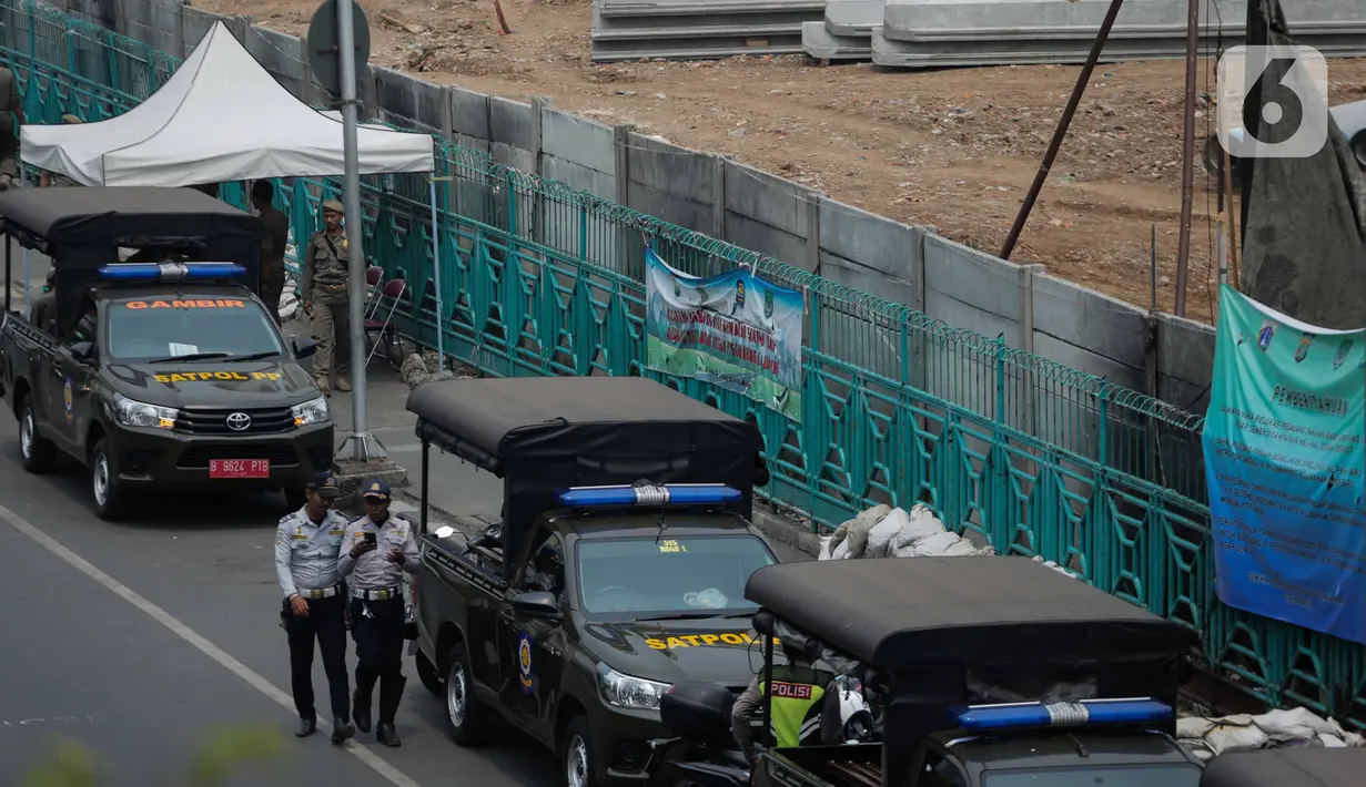 Petugas tim gabungan berjaga di trotoar Jalan Stasiun Senen, Pasar Senen, Jakarta, Rabu (11/12/2019). Pemerintah Kota Jakarta Pusat mengerahkan sekitar 500 petugas tim gabungan untuk menjaga kawasan tersebut agar pedagang kaki lima (PKL) tidak kembali berjualan. (Liputan6.com/Faizal Fanani)