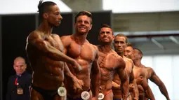 Para peserta pria bersiap tampil dalam kompetisi binaraga Mr. Olympia Amateur South America di Medellin, Kolombia (18/2). (AFP Photo / Raul Arboleda)