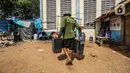 Penjual membawa jeriken berisi air bersih ke rumah pembeli di Kawasan Muara Angke, Jakarta Utara, Rabu (30/8/2023). (Liputan6.com/Faizal Fanani)