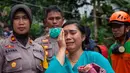 Seorang wanita menangis dekat Tim SAR saat menemukan keluarganya yang meninggal dalam bencara tanah longsor di Gowa, Sulawesi Selatan, Jumat (25/1). Hingga 25 Januari 2018, tercatat 33 orang meninggal dunia. (YUSUF WAHIL/AFP)