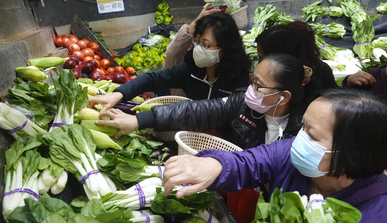 Pelanggan mengenakan masker, membeli sayuran segar di toko pasar basah di Hong Kong, Rabu, 9 Februari 2022. Hong Kong memberlakukan langkah-langkah jarak sosial yang paling ketat untuk mempertahankan kebijakan nol COVID-19 di tengah lonjakan kasus yang dipicu Varian Omicron. (AP Photo/Vincent Yu)