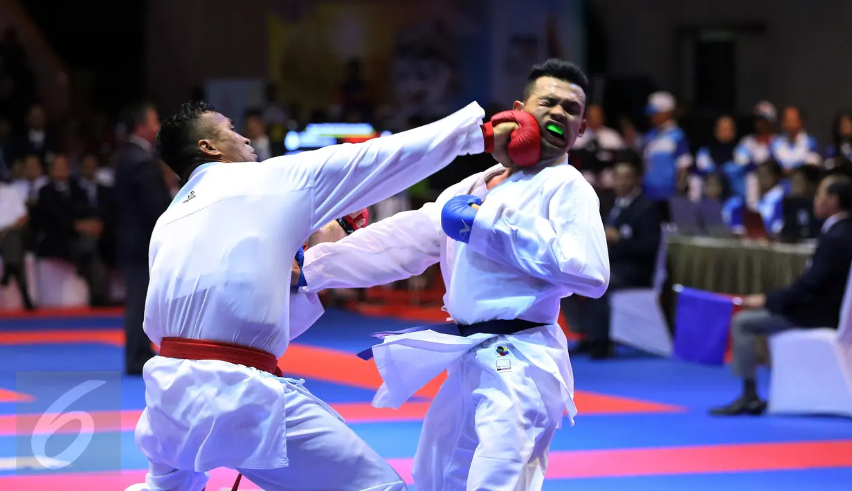 Karateka Jawa Timur, Umar Syarief (kiri) menyarangkan pukulan ke arah Caesar George (Jakarta) di kelas Kumite Individu Putra +84 kg senior PON XIX di Sabuga, Bandung, Minggu (18/9). Umar menang telak 9-1 atas Caesar. (Liputan6.com/Helmi Fithriansyah)