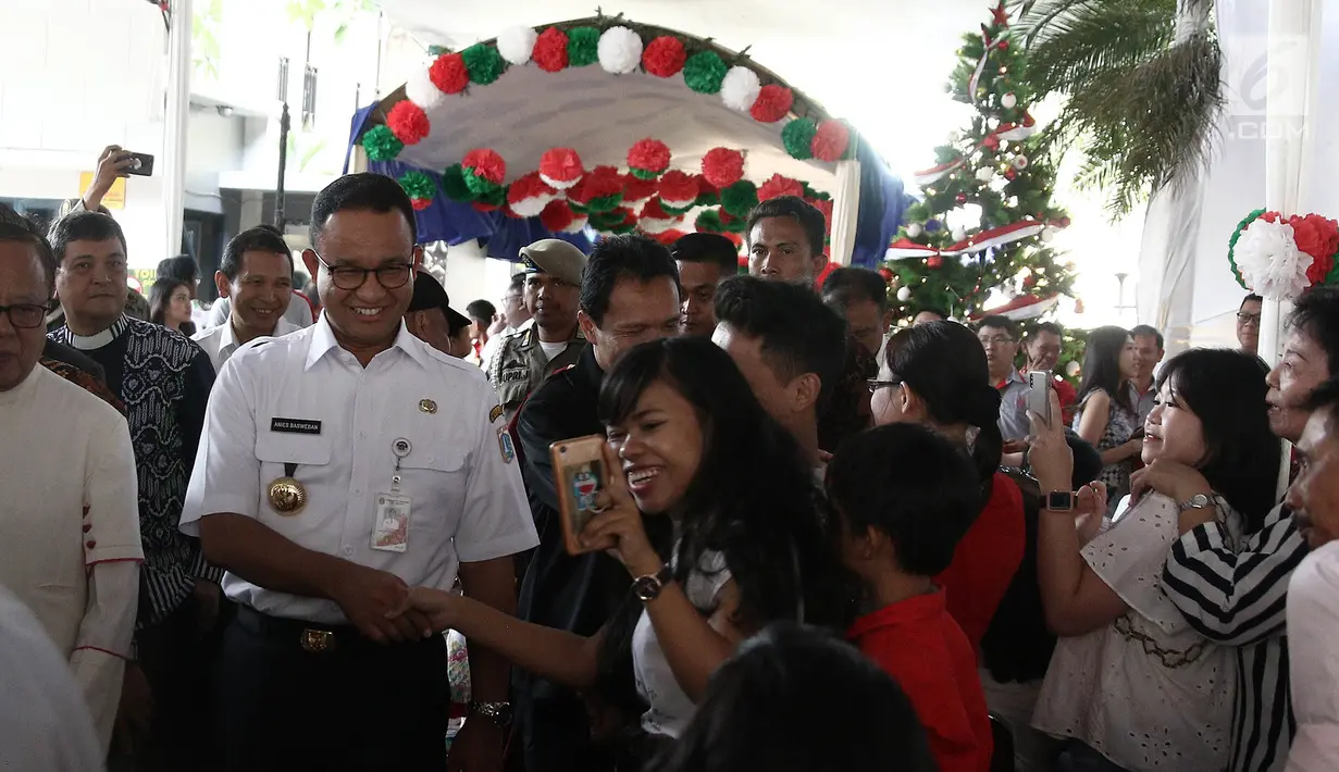Gubernur DKI Jakarta Anies Baswedan menyapa jamaah menjelang misa malam Natal di Gereja Katedral, Jakarta, Senin (24/12). Anies menyampaikan terima kasih kepada seluruh jamaah dalam menjaga meneduhkan kedamaian. (Liputan6.com/Herman Zakharia)