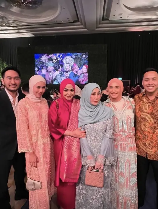 Syahnaz Sadiqah tampil dengan dress pink dipadukan kerudung putih. Ia pun membawa handbag silver dari Dior. [@syahnazs]