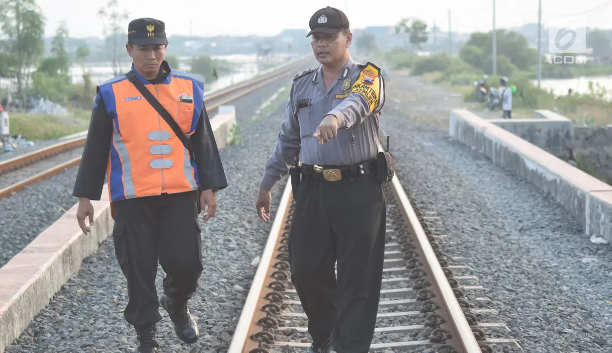 Petugas gabungan dari Polsuska dan Babinkamtibmas Kemijen Semarang memeriksa rel kereta api dan alat pemindah jalur kereta di Jalur Kemijen, Minggu (3/6). Pemeriksaan untuk pengamanan jalur kereta api jelang arus mudik lebaran. (Liputan6.com/Gholib)