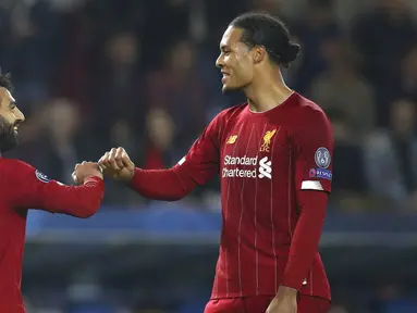 Penyerang Liverpool, Mohamed Salah bersama Virgil van Dijk merayakan gol ke gawang KRC Genk pada laga Liga Champions 2019 di KRC Genk Arena, Rabu (23/10). Liverpool menang 4-1 atas KRC Genk. (AP/Francisco Seco)