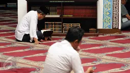 Sejumlah umat muslim bertadarus usai melaksanakan salat di Masjid Cut Meutia, Jakarta, Rabu (15/6/2016). Masjid Cut Meutia memiliki mihrab (tempat imam) yang diletakkan di samping kiri dari saf salat. (Liputan6.com/Helmi Fithriansyah)