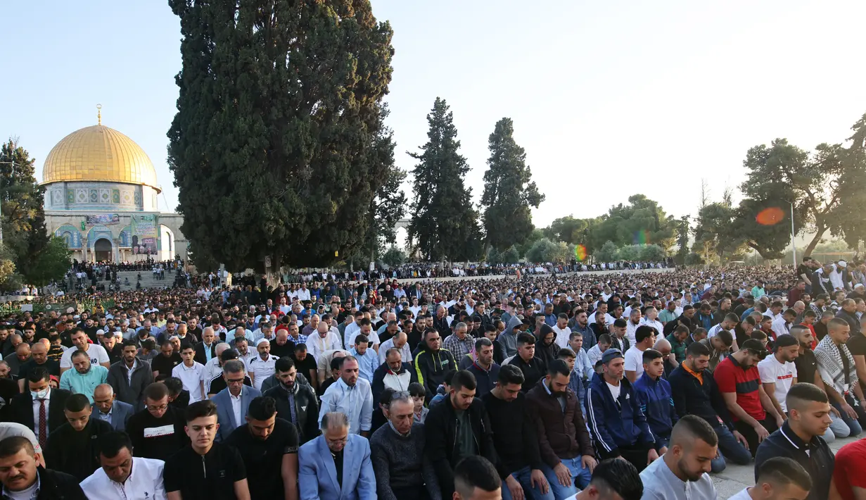 Umat Muslim melaksanakan sholat Idul Fitri di luar masjid Kubah Batu di kompleks masjid Al-Aqsa, Yerusalem Tua (13/5/2021).  Rentetan tembakan roket dari Gaza dan serangan udara Israel yang mematikan sebagai pembalasan. (AFP/Ahmad Gharabli)