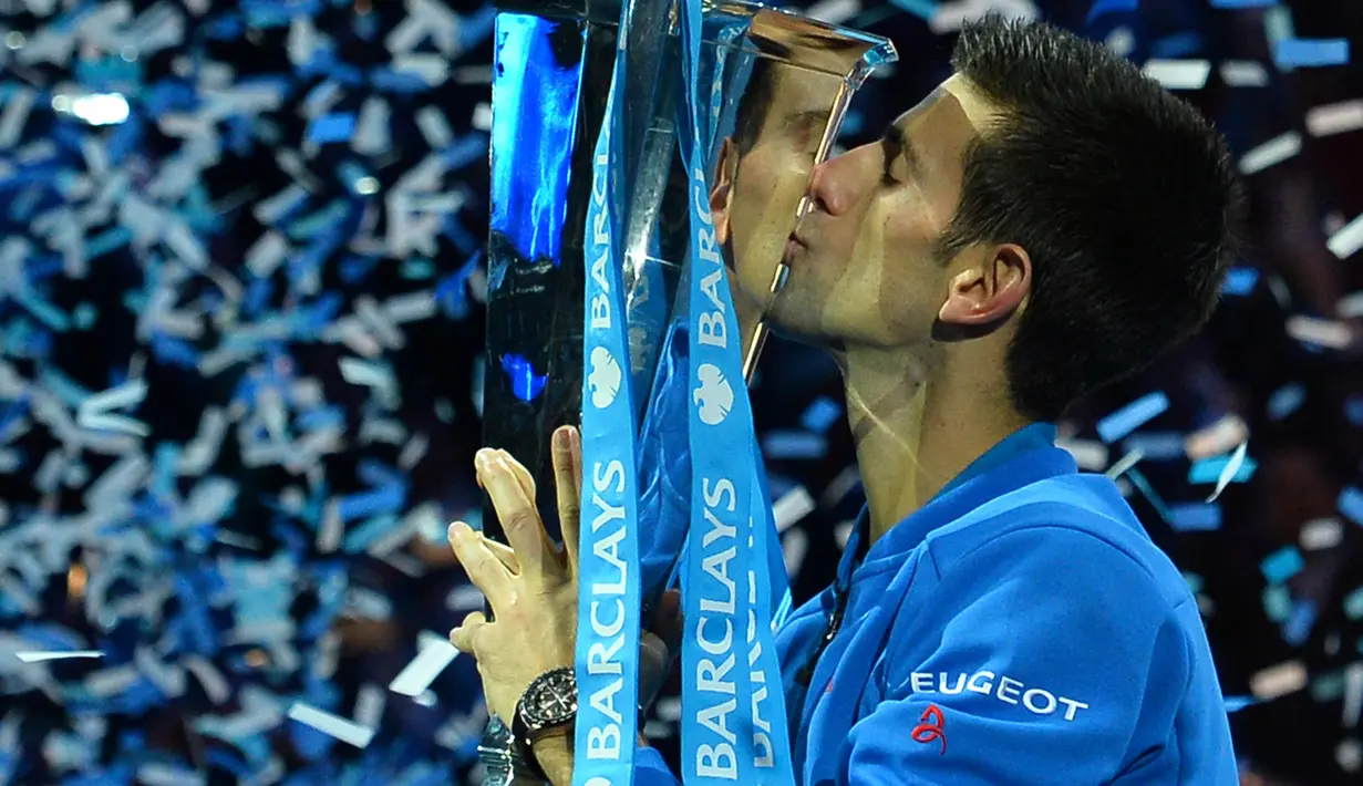 Novak Djokovic mencium trofi juara turnamen tenis ATP World Tour Finals di London, Inggris, (22/11/2015). (AFP Photo/Glyn Kirk)