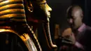 Seorang pria memfilmkan topeng emas Raja Tutankhamun saat perayaan untuk menghormati Hari Pariwisata Dunia dan peringatan 200 tahun Egyptology sebagai ilmu di Museum Mesir, Kairo, Mesir, 27 September 2022. (AP Photo/Amr Nabil)