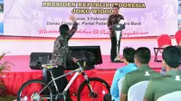 Seorang warga melambaikan tangan ke Presiden Jokowi usai mendapat hadiah sepeda dalam HPN 2018 di Padang, Sumatera Barat, Jumat (9/2). (Liputan6.com/Pool/Biro Setpres)