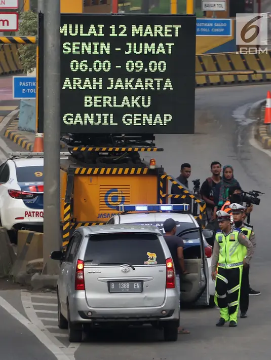 Petugas mengarahkan kendaraan berplat genap berputar balik di Gerbang Tol Bekasi Barat 1, Bekasi, Jawa Barat, Selasa (13/3). Hari kedua penerapan ganjil genap, masih banyak kendaraan berputar balik di gerbang tol tersebut. (Liputan6.com/Arya Manggala)