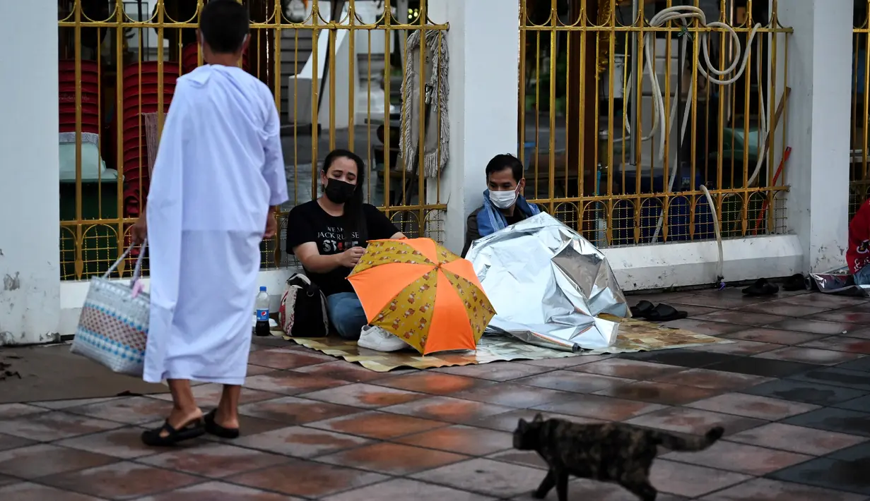 Warga menunggu tiket tes swab Covid-19 gratis setelah berkemah semalam di Wat Phra Sri Mahathat Woramahawihan, Bangkok, Jumat (9/7/2021). Thailand pada Kamis (8/7/2021), mencatat rekor 75 kematian Covid-19 dalam 24 jam terakhir, sehingga jumlah kematian menjadi 2.462. (Lillian SUWANRUMPHA/AFP)