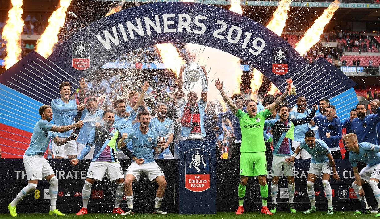 Selebrasi para pemain Manchester City dengan trofi Piala FA 2018/2019 setelah mengalahkan Watford pada laga final di Wembley Stadium, London (18/5/2019). Klub terakhir yang mampu menyandingkan raihan trofi Liga Inggris dengan Piala FA dalam satu musim di Era Premier League adalah Manchester City. Momen itu terjadi pada musim 2018/2019 saat The Citizens menjadi klub pertama Inggris yang mampu meraih treble winners domestik dengan menjuarai Liga Inggris, Piala FA dan Piala Liga sekaligus. (AFP/Daniel Leal)