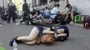 Seorang Wanita tidur di jalanan sekitar Gedung Kementerian Pendidikan, Taipei, Taiwan, Jumat (31/7/2015). Ratusan pelajar Taiwan turun ke jalan menuntut pengunduran diri menteri pendidikan yang mengedarkan buku sekolah menyesatkan. (REUTERS/Pichi Chuang)