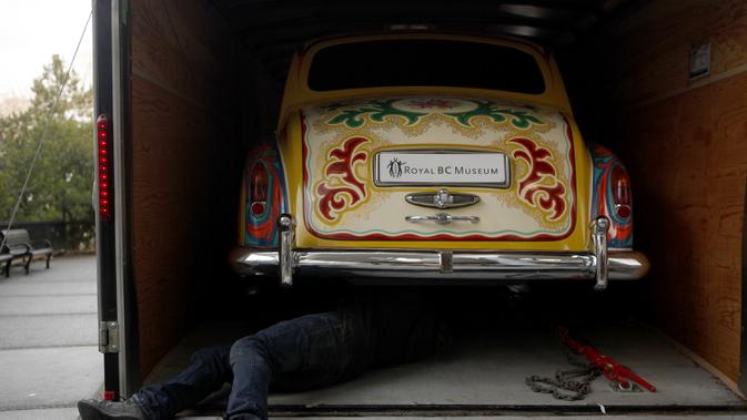 Seorang pria melihat bagian bawah Rolls-Royce limusin touring Phantom V milik John Lennon Museum Royal BC di Victoria, British Columbia (27/1/2020). Fitur pelengkap masih sama ketika mobil pertama kali dipesan. (Chad Hipolito/The Canadian Press via AP)