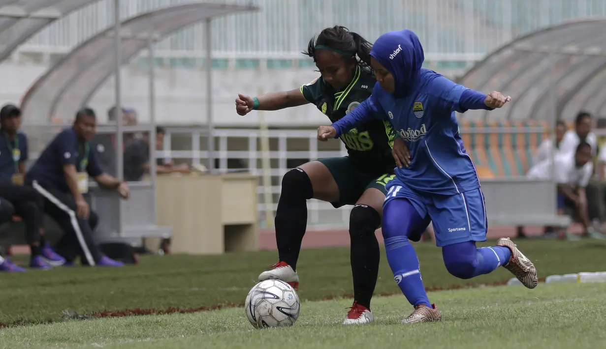 Gelandang Tira Persikabo Putri, Risda Yulianti, berebut bola dengan gelandang Persib Bandung Putri, Tia Darti, pada laga Liga 1 Putri 2019 di Stadion Pakansari, Bogor, Kamis (31/10). Persikabo Putri bermain imbang 1-1 atas Persib Putri. (Bola.com/Yoppy Renato)