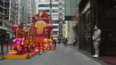 Seorang asisten toko yang mengenakan masker menunggu pelanggan di sebuah toko di Hong Kong, Jumat (28/1/2022). Hong Kong memangkas masa karantina wajib bagi orang-orang yang datang dari luar negeri dari 21 menjadi 14 hari. (AP Photo/Kin Cheung)