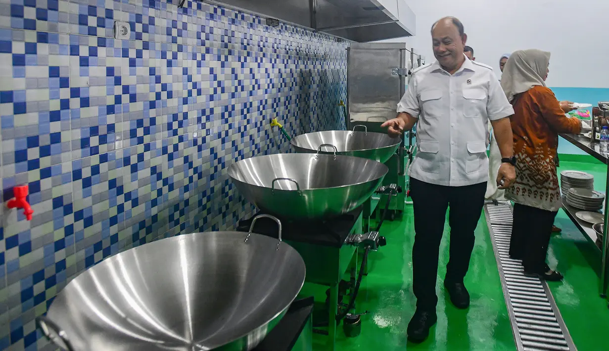 Melalui skema terintegrasi, kebutuhan bahan pangan dapur dipasok langsung dari petani, nelayan, peternak, serta pedagang tradisional setempat. Pola ini memberikan kepastian pasar bagi para pemasok, sekaligus membuka peluang usaha bagi pelaku UKM kuliner dan jasa transportasi lokal. Dengan demikian, pemenuhan gizi anak berjalan seiring dengan penguatan ekosistem ekonomi yang berkelanjutan. Tampak dalam foto, Kepala Badan Gizi Nasional (BGN), Dadan Hindayana menyaksikan dapur Satuan Pelayanan Pemenuhan Gizi (SPPG) saat Grand Launching Nasional SPPG Terintegrasi di Lapangan Dapur SPPG-MBG kawasan Tanah Sareal Kota Bogor, Jawa Barat, Selasa (23/12/2025). (merdeka.com/Arie Basuki)