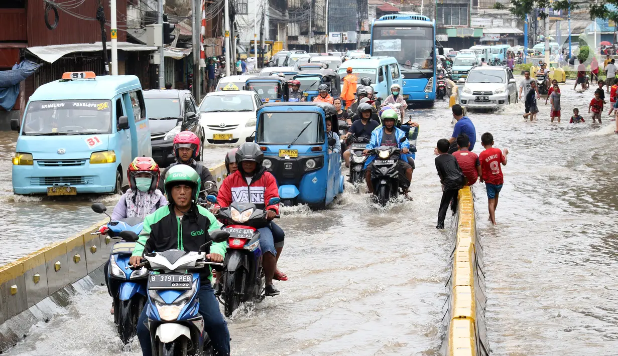 Pengendara menerobos genangan air di sebagian ruas Jalan Jatinegara Barat, Jakarta, Rabu Rabu (1/1/2020). Hujan yang mengguyur Jakarta sejak Selasa sore (31/12/2019) mengakibatkan banjir di sejumlah titik di Jakarta. (Liputan6.com/Helmi Fithriansyah)