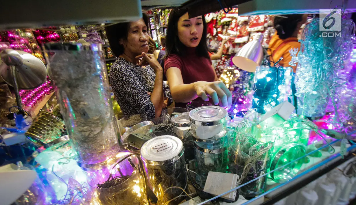 Calon pembeli memilih pernak-pernik Natal di kawasan Pasar Asemka, Jakarta, Selasa (12/12). Berbagai pernak-pernik Natal untuk hiasan pohon dan rumah dijual dengan harga Rp 100 ribu - Rp 10 juta tergantung model dan variasi. (Liputan6.com/Faizal Fanani)