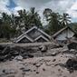 Batu-batu besar tersebar di depan rumah-rumah yang rusak di Dusun Kamar Kajang, Lumajang, Kamis (9/12/2021). Luapan air sungai bercampur material lahar dingin erupsi Gunung Semeru merendam puluhan rumah akibat diguyur hujan deras pada Selasa (7/12) dan Rabu (8/12) malam. (Juni Kriswanto/AFP)