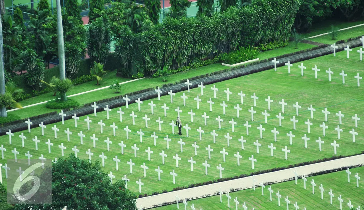 Petugas terlihat membersihkan salah satu makam di Ereveld Menteng Pulo, Jakarta Selatan, Jumat (29/4). Pemakaman tersebut merupakan salah satu dari dua ereveld yang berada di Jakarta. (Liputan6. com/Gempur M Surya)