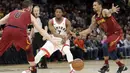 Pemain Toronto Raptors, Kyle Lowry (tengah) melakukan umpan melewati adangan dua pemain Cleveland Cavaliers pada lanjutan NBA basketball game di Quicken Loans Arena, (21/3/2018) Cleveland. Cavs menang 132-129. (AP/Tony Dejak)