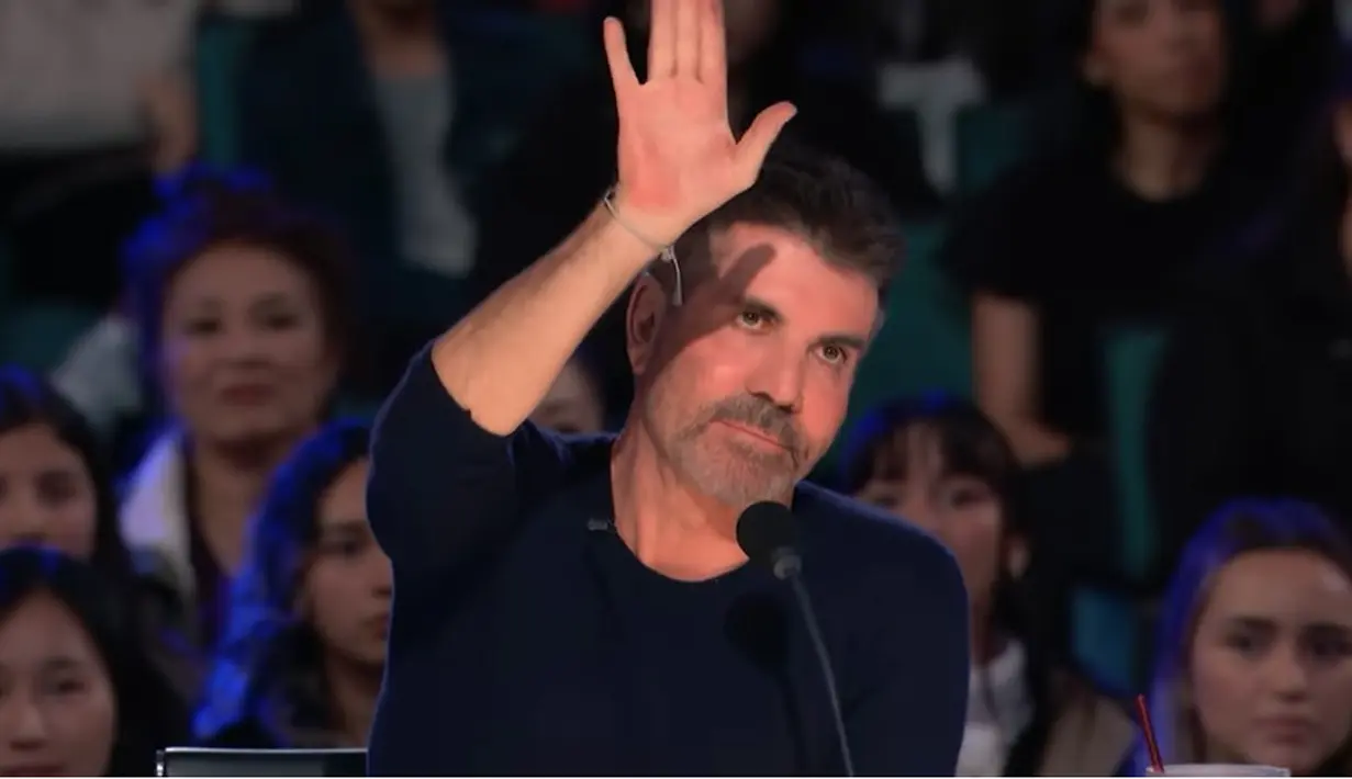Momen Simon Cowell mengangkat tangan meminta Cakra Khan berhenti menyanyikan lagu yang dibawakan. "Bisa nggak bawain lagu lainnya?" tanya Simon Cowell. [Youtube/America's Got Talent]