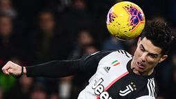Striker Juventus, Cristiano Ronaldo, mencetak gol dengan tandukan kepala ke gawang Sampdoria pada laga Serie A 2019 di Stadion Luigi Ferraris, Rabu (18/12). Juventus menang 2-1 atas Sampdoria. (AFP/Marco Bertorello)