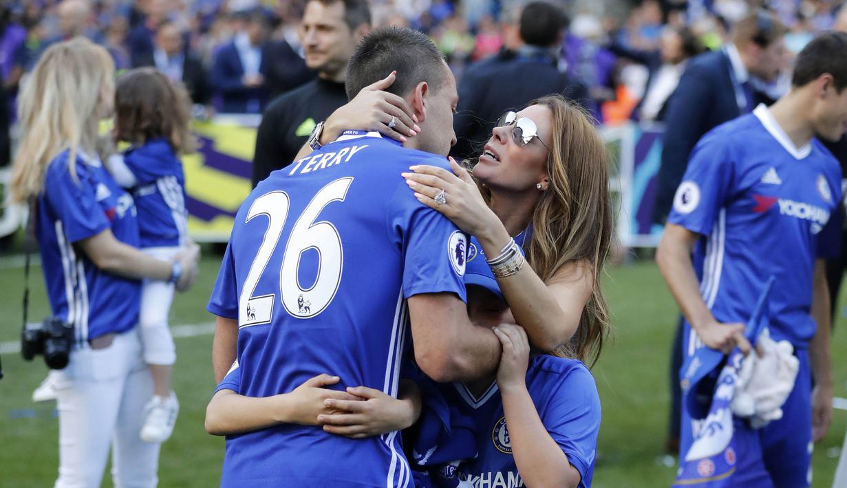 Kapten Chelsea, John Terry, memeluk anak dan istrinya usai laga melawan Sunderland di Stamford Bridge, Minggu (21/5/2017). Terry resmi mengakhiri kiprahnya selama 22 tahun di Chelsea. (AP/Frank Augstein)