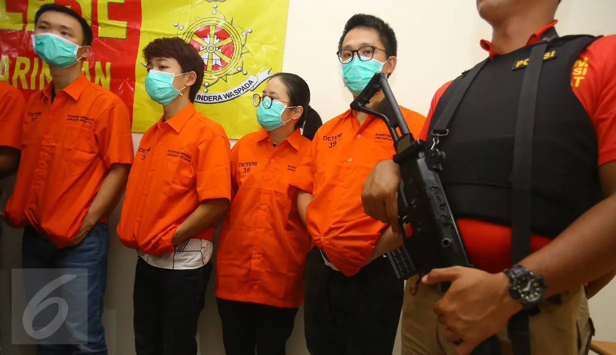 Petugas mengamankan tujuh orang tersangka WNA asal China yang diduga melakukan kegiatan kejahatan cyber crime, Kapuk Muara, Jakarta, Selasa (24/1). (Liputan6.com/ Immanuel Antonius)