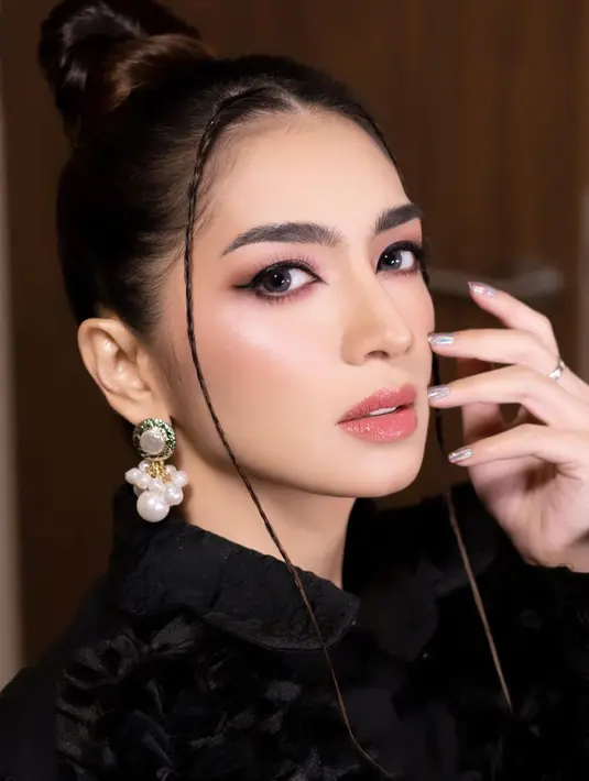 Makeup glossy yang tampak natural bernuansa merah muda yang lembut terlihat menawan pada Angel Karamoy. Outfit hitam dengan rambut dicepol ke atas dan disisakan sedikit bagian yang kemudian dikepang, berbaur sempurna dengan makeupnya yang menawan. Foto: Instagram.