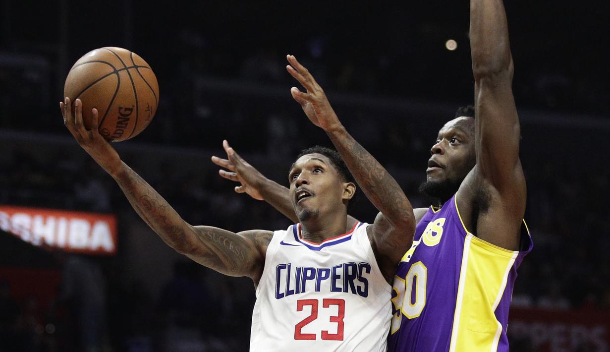 Aksi pemain Clippers, Lou Williams (kiri) melakukan lay up melewati adangan pemain Lakers, Julius Randle pada laga NBA basketball games di Staples Center, Los Angeles, California, (27/11/2017). Clippers menang atas Lakers 120-115. (AP/Jae C. Hong)